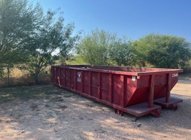 Large orange local dumpster rental filled with construction debris.